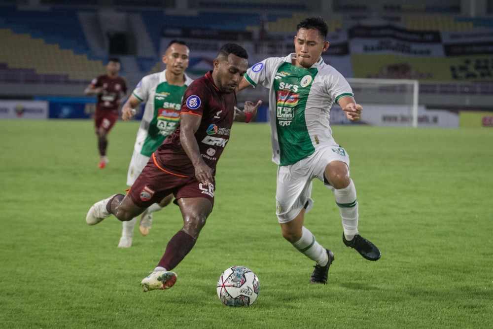 Pesepak bola Borneo FC Terens Puhuri berebut bola dengan pesepak bola PSS Sleman Derry Rachman Noor pada pertandingan Liga I di Stadion Manahan, Solo, Jawa Tengah, Senin (1/11).ANTARA/M. AYUDHA